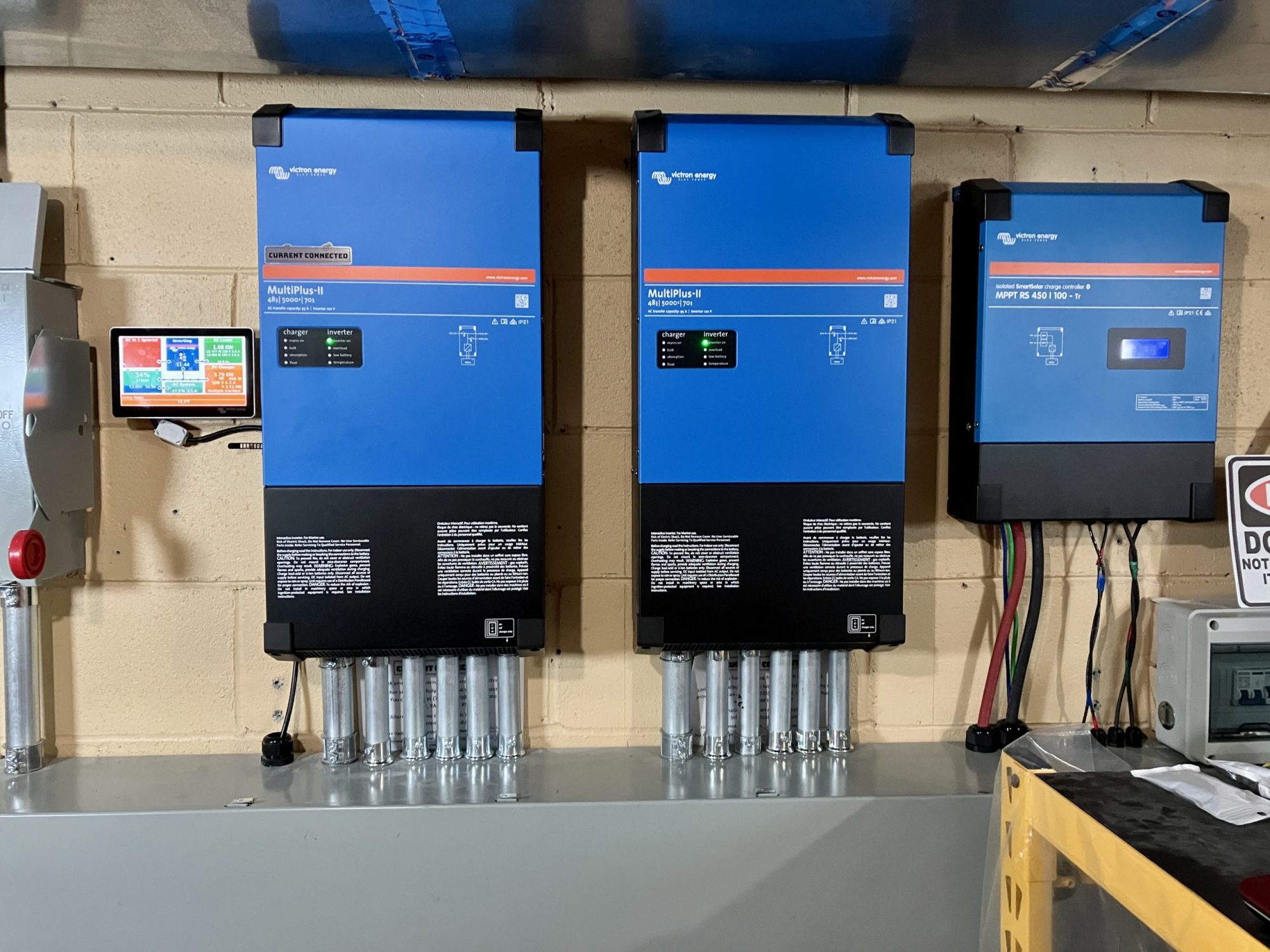 Victron MultiPlus-II inverters and Cerbo GX mounted on the wall of Adam's power room
